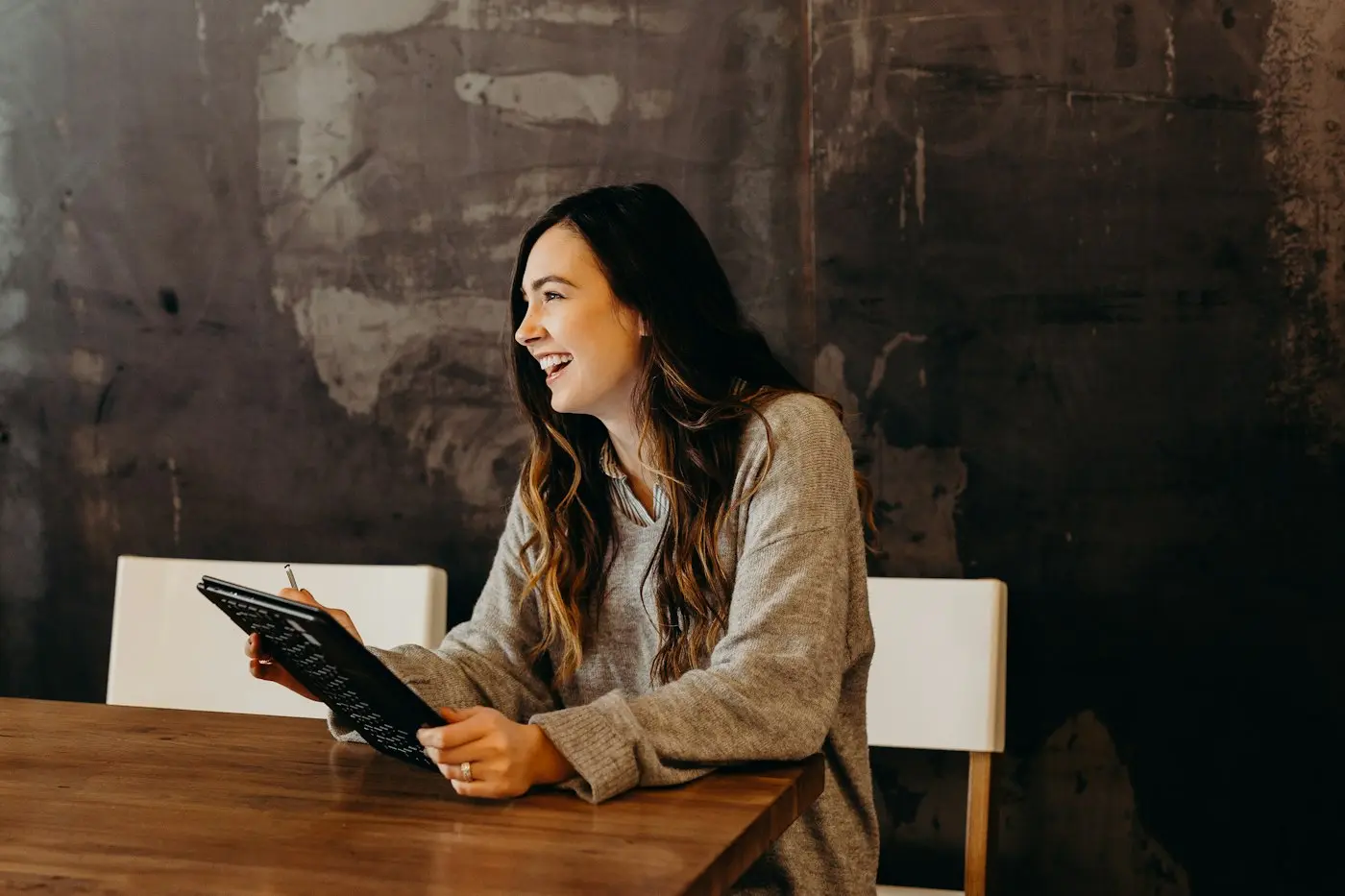 A colleague smiling as she reviews work on a tablet.
