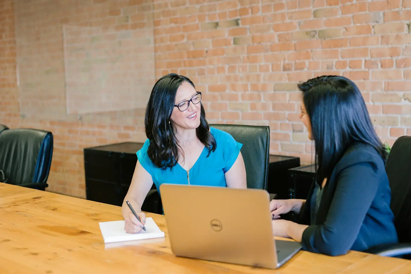 Two people in a working session at a laptop.