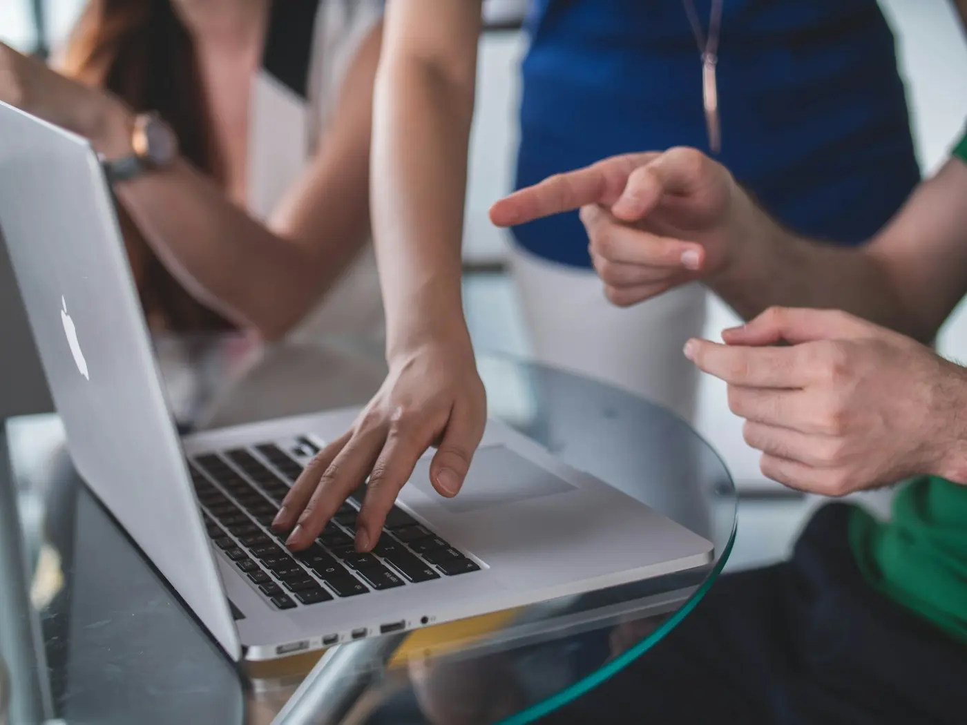 Hands pointing at a laptop screen during a review.