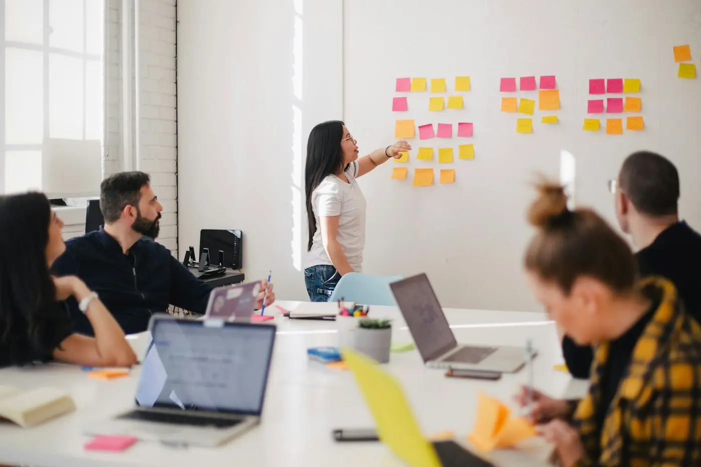 A team planning with sticky notes on a glass wall.