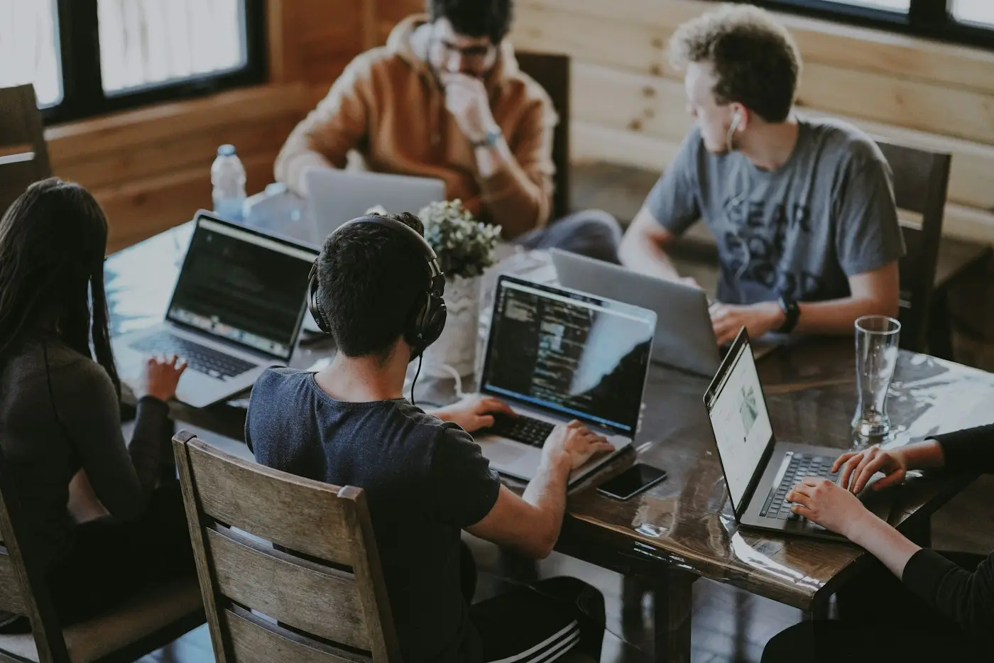 A small team working together on laptops around one table.